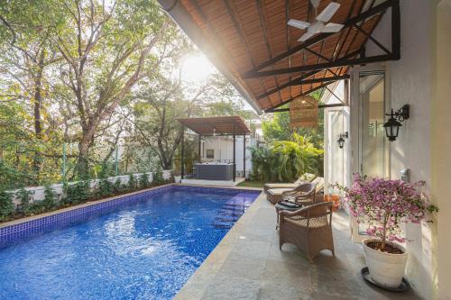 a swimming pool in the backyard of a house at LohonoStays Colina Villa E in Vagator