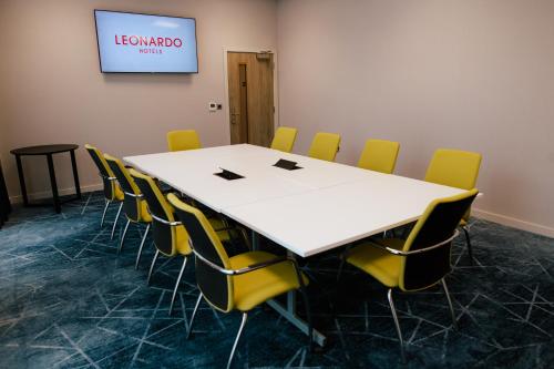 a conference room with a white table and yellow chairs at Leonardo Hotel Bristol City in Bristol