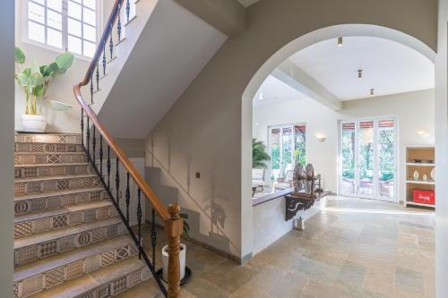 an arched doorway leads to theoyer of a home with a staircase at LohonoStays Colina Villa E in Vagator