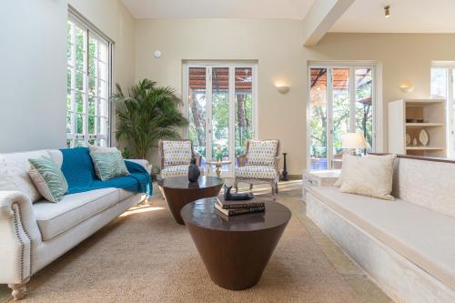 a living room with a couch and a table at LohonoStays Colina Villa E in Vagator