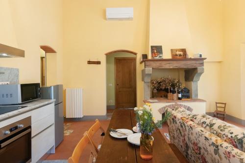 a kitchen and living room with a table and a couch at Podere in Volpaia in Radda in Chianti