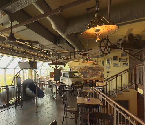 a restaurant with tables and chairs and a car on the wall at Mercure Hotel Riesa Dresden Elbland in Riesa