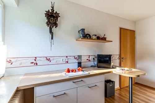 una cocina con armarios blancos y una barra con tomates. en Ferienwohnung Kuckucksnest, en Lahr