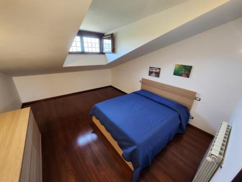 1 dormitorio con 1 cama azul en el ático en Marco Simone Roma Golf Club, en Marco Simone