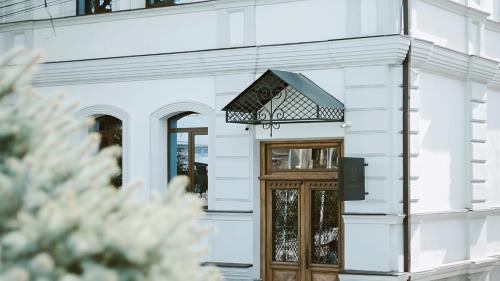 uma porta da frente de um edifício branco com uma placa por cima em EPIGRAPH Design Hotel em Tbilisi