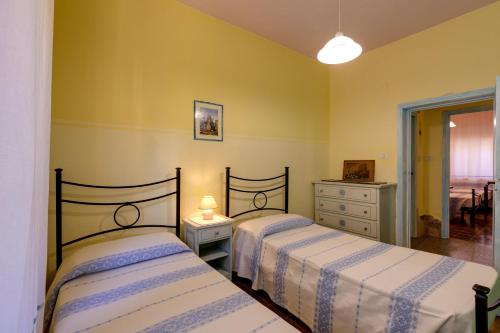 - une chambre avec 2 lits et une commode dans l'établissement Paolo e Francesca, à Bosa Marina