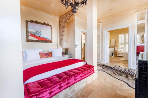 a bedroom with a large bed with a red blanket at Birkenhead House in Hermanus