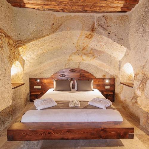 a bedroom with a bed in a stone room at Canyon Cave Hotel in Urgup