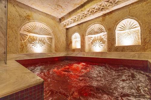 a room with a large tub filled with red water at Canyon Cave Hotel in Urgup