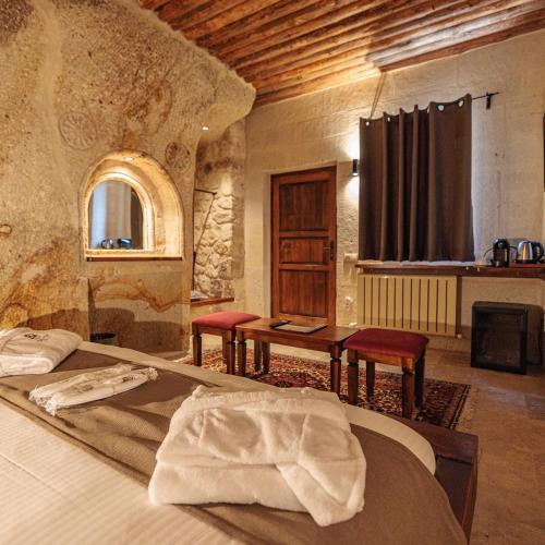 a bedroom with a bed and a table and chairs at Canyon Cave Hotel in Urgup
