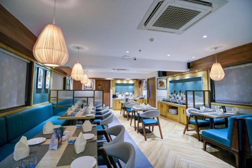 a restaurant with tables and chairs and a bar at Cozzet Victoria Hotel in Bhubaneshwar