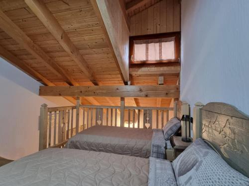 a bedroom with a bed and a window in a cabin at Appartamento Adamello 7 in Pinzolo
