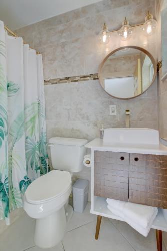 a bathroom with a toilet and a sink and a mirror at LoKal Rental Tropical Florida destination in Fort Lauderdale