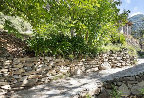 a stone retaining wall next to a road at Ca' Kira in Molini di Triora