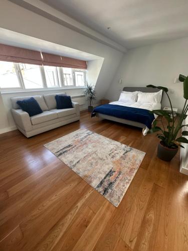 a bedroom with a bed and a couch and a rug at Studio flat in the heart of Hampstead, London in London