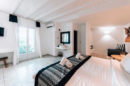 a bedroom with a large bed and a living room at Mr & Mrs White Mykonos in Platis Yialos Mykonos