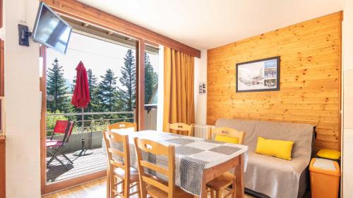 une salle à manger avec une table, des chaises et une télévision dans l'établissement V du Bachat B02 - Appt grande terrasse 6 pers, à Chamrousse
