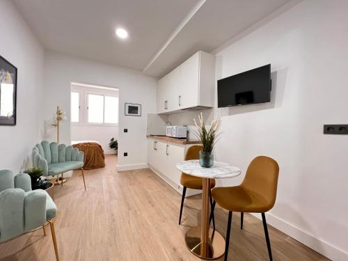 Una cocina y una sala de estar con mesa y sillas. en Crysoyle Apartment Barcelona Next to Camp Nou, en Hospitalet de Llobregat