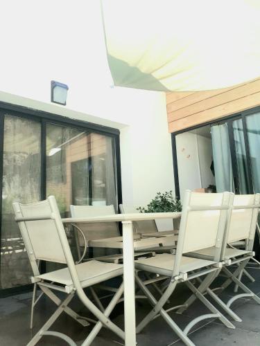 une table et des chaises assises sur une terrasse dans l'établissement Charmant duplex avec jacuzzi, à Aumelas