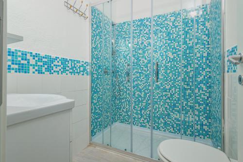 a bathroom with a shower with a toilet and a sink at Casa Salina Bamba in San Teodoro