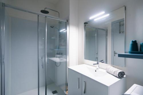a bathroom with a glass shower and a sink at La Verrière by la Maison de Marc- Poitiers Centre - parking et terrasse in Poitiers