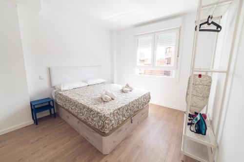 a bedroom with a bed with two stuffed animals on it at ALFALFA B Apartments in Madrid