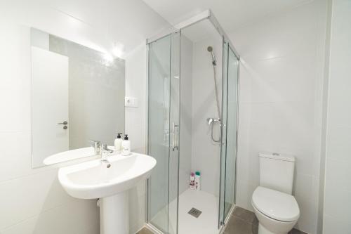 y baño blanco con lavabo y ducha. en ALFALFA A Apartments, en Madrid