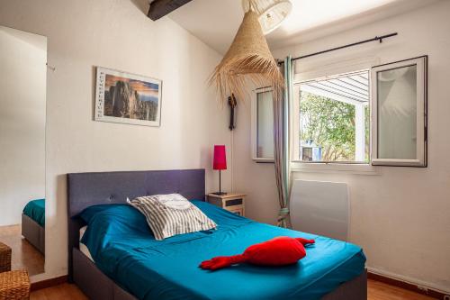 a bedroom with a blue bed with a red stuffed animal on it at Le cabanon de Valérie in Sanary-sur-Mer