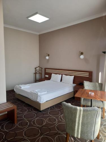 a bedroom with a bed and a table and chairs at Aksoy Otel in Adana