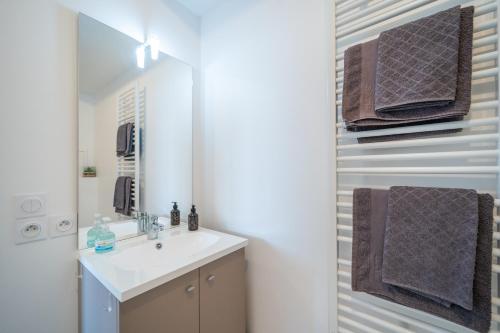 a bathroom with a sink and a mirror at Carré d'As - Appartement de standing in Le Bourget