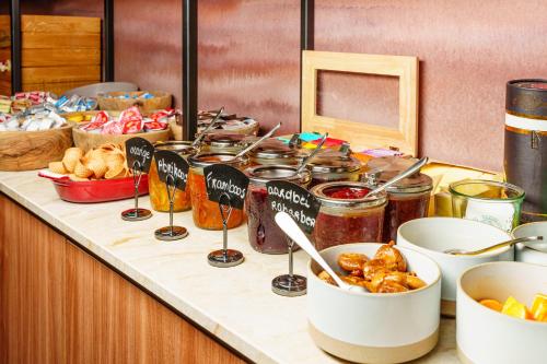 a counter top with jars of food and other foods at Dune Hotel Nieuwpoort in Nieuwpoort