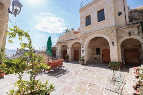 a stone building with a bench in a courtyard at Canyon Cave Hotel in Urgup