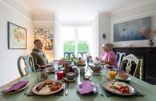a man and woman sitting at a table with food at The Mount B&B in Keswick