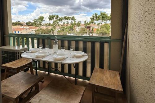 een tafel en stoelen op een balkon met uitzicht bij La Mezza de Gruissan in Gruissan