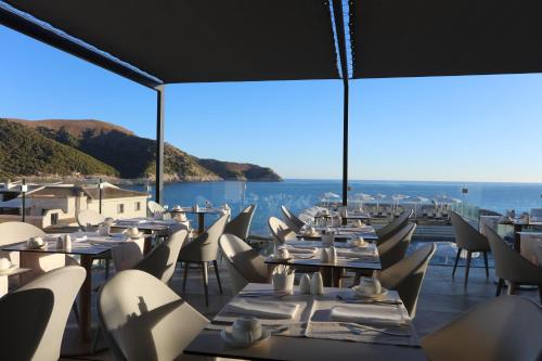 a restaurant with tables and chairs and a view of the ocean at Mar Azul Pur Estil Hotel & Spa - Adults only in Cala Ratjada