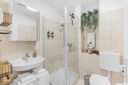 uma casa de banho com um chuveiro, um WC e um lavatório. em PRIME - City Apartment für 6 - Neu & Modern em Munique