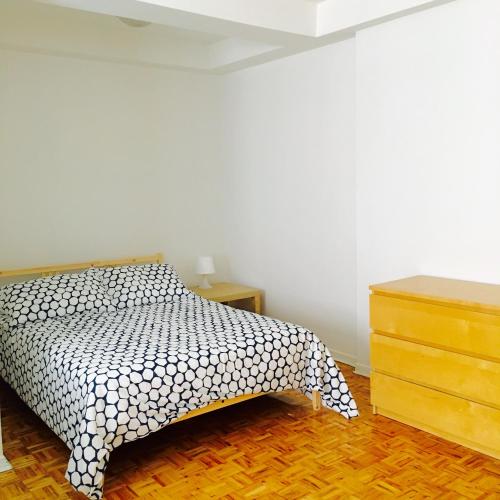 Schlafzimmer mit einem Bett mit einer schwarzen und weißen Tagesdecke in der Unterkunft Stylish Montreal Apartment: Comfortable Stay in the Golden Square Mile in Montreal