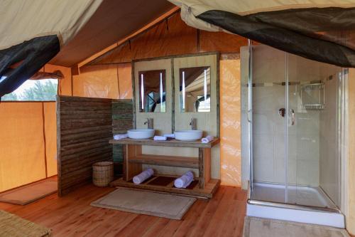 ein Badezimmer mit zwei Waschbecken und einer Dusche in einem Zelt in der Unterkunft Glamping Kenya Mt. Kenya Lodge in Naro Moru