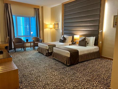 a hotel room with two beds in a room at Copthorne Hotel Sharjah in Sharjah