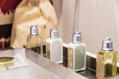 a counter with bottles of soap and a mirror at Carlota Sustainable Design Hotel in Quito