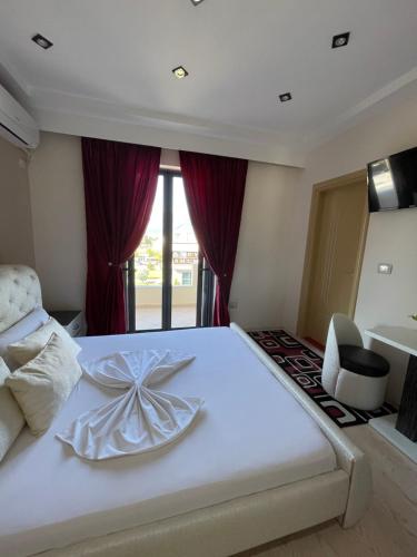 a bedroom with a white bed with a bow on it at Hotel Selfo in Gjirokastër