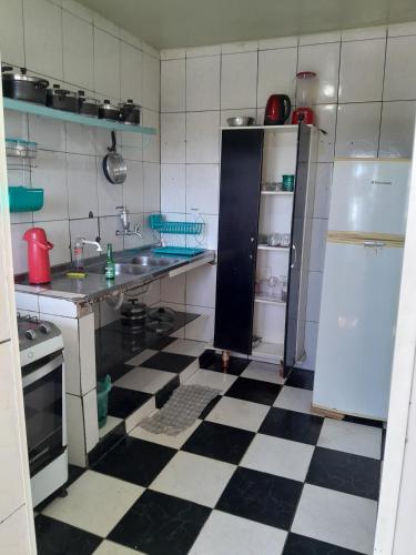 a kitchen with a black and white checkered floor at Apartamento Anchieta 7 Belo in Rio de Janeiro