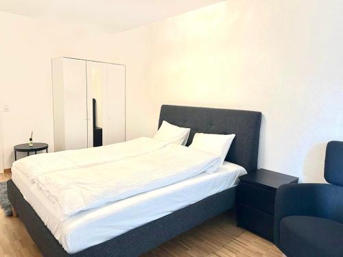 Interlaken Best View Deluxe Apartment في إنترلاكن: غرفة نوم بسرير كبير مع كرسي ازرق