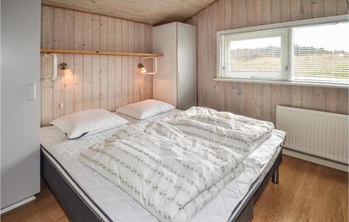 a large bed in a room with a window at Nice Home In Hjrring With 4 Bedrooms, Sauna And Indoor Swimming Pool in Lønstrup
