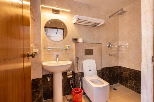 a bathroom with a sink and a toilet and a mirror at Ananta Home in Kathmandu