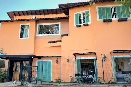 een oranje huis met een tafel ervoor bij Apto Roma na Vila Paraíso: um cantinho feliz in Maringá