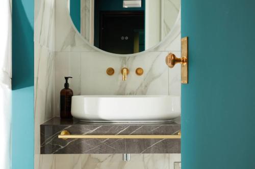 a bathroom with a white sink and a mirror at The Townhouse in Udine