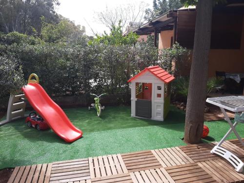 une aire de jeux avec un toboggan et une maison de jeux dans l'établissement Ca San Vito Lo Capo Villa Maria, à San Vito Lo Capo