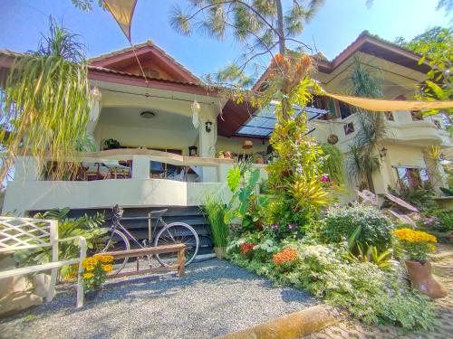 a house with a bike parked in front of it at ม่วนโฮม muan home café&stay in Ban Don