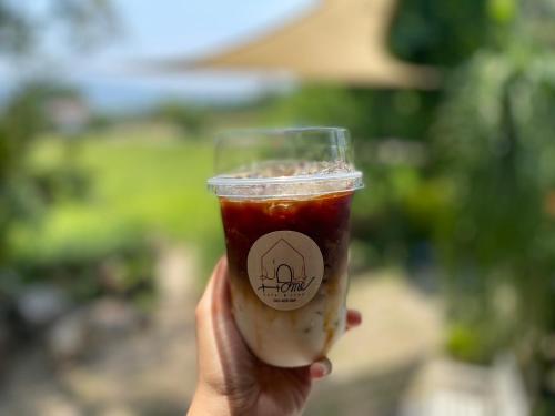 a person holding a drink in a cup at ม่วนโฮม muan home café&stay in Ban Don